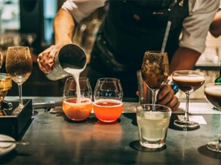Coctelería para principiantes con bartender preparando varios cócteles